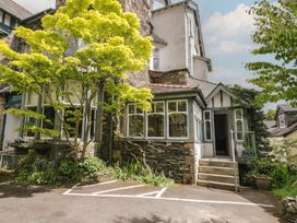 An exterior view of a house with a tree and parking space at The Boundary in Windermere