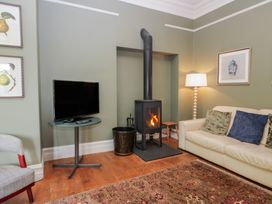 A living room with a stove and television at The Boundary in Windermere