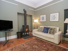 A living room with a wood stove and television at The Boundary in Windermere