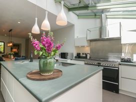 A kitchen with a stove, sink, and flowers in a vase at The Boundary in Windermere