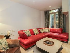 A living room with a red sofa and a coffee table at The Boundary in Windermere