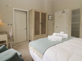 A bedroom with a bed, wardrobe, desk and chair at The Boundary in Windermere
