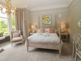 A bedroom with a four-poster bed and a chair at The Boundary in Windermere