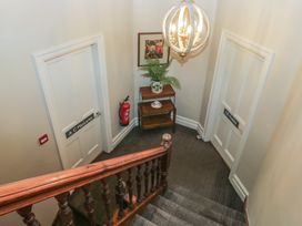 A staircase leading to doors and a table with a plant and picture at The Boundary Windermere