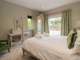 A bedroom with a bed, mirror, chair, and window at The Boundary in Windermere