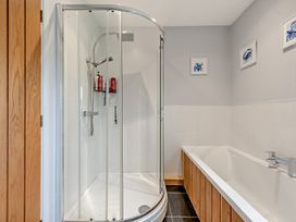 A bathroom with a shower and bathtub at Sea Haze in Tenby