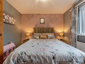 A bedroom with a bed and nightstands at Sea Haze in Tenby