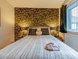 A bedroom with a bed and bedside lamp at Sea Haze in Tenby