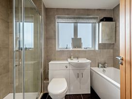A bathroom featuring a shower, toilet, sink, and bathtub at Sea Haze in Tenby