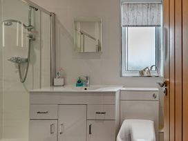 A bathroom with a shower, sink, and toilet at Sea Haze in Tenby