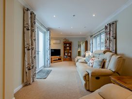 A living room with a sofa and TV at Sea Haze in Tenby