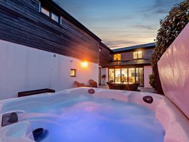 An outdoor area with a hot tub and seating at Sea Haze in Tenby