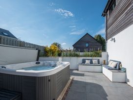An outdoor area with a hot tub and seating at Sea Haze in Tenby