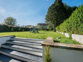 A garden with grass and steps leading down at Sea Haze in Tenby