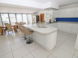 A kitchen with a dining table and chairs at Sea Haze in Tenby
