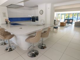 A kitchen with an island and stools at Sea Haze in Tenby