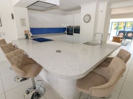 A kitchen with a large island and bar stools at Sea Haze in Tenby
