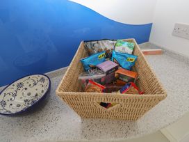 A basket with snack items on a countertop at Sea Haze in Tenby