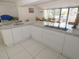 A kitchen with a countertop sink and stove at Sea Haze in Tenby