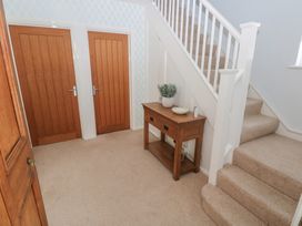 A hallway with a table and stairs at Sea Haze in Tenby