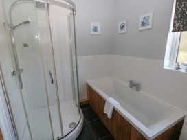 A bathroom with shower and bathtub at Sea Haze in Tenby
