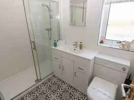 A bathroom with a shower, sink, and toilet at Sea Haze in Tenby