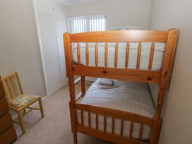 A bedroom with a bunk bed and a chair at Sea Haze in Tenby