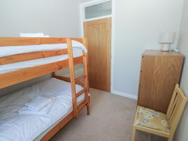 A bedroom with a bunk bed and a chair at Sea Haze in Tenby