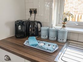 A kitchen countertop with a coffee machine, kettle, canisters, and towels at Lodge 1 in Norwich