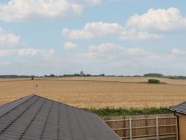 A field with a distant building and a roof at Lodge 1 Norwich