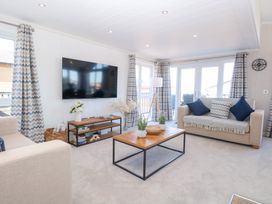 A living room with a television and coffee table at Sandy Snug in Bacton
