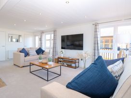 A living room with a television and coffee table at Sandy Snug in Bacton