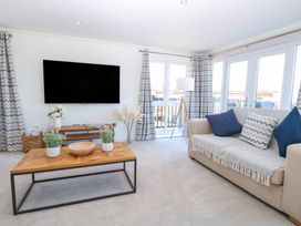 A living room with a tv and a coffee table at Sandy Snug in Bacton