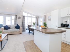 A living room with a sofa and dining table at Sandy Snug in Bacton