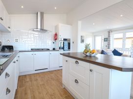 A kitchen with a sink and appliances at Sandy Snug in Bacton