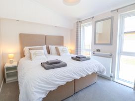 A bedroom with a bed and bedside tables at Sandy Snug in Bacton