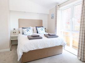 A bedroom with a bed and bedside table at Sandy Snug in Bacton