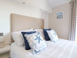 A bedroom with a bed and pillows at Sandy Snug in Bacton