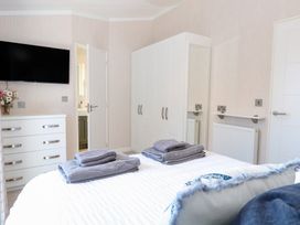 A bedroom with a bed and towels on it at Sandy Snug in Bacton