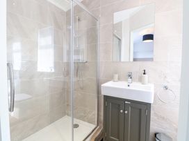 A bathroom with a shower and sink at Sandy Snug in Bacton