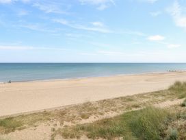 A beach with sand and sea at Sandy Snug in Bacton