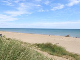 A beach with sand and ocean view at Sandy Snug in Bacton