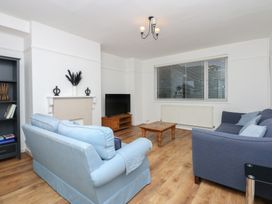 A living room with sofas, a coffee table, and a television at Tan Y Mynydd in Dwygyfylchi