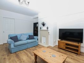 A living room with a sofa and television at Tan Y Mynydd in Dwygyfylchi