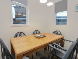 A dining room with a wooden table and chairs at Tan Y Mynydd in Dwygyfylchi