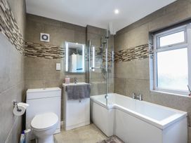 A bathroom with a bathtub, toilet, sink, and shower at Tan Y Mynydd in Dwygyfylchi