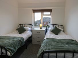 A bedroom with two beds and a drawer unit at Tan Y Mynydd in Dwygyfylchi
