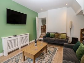 A living room with a television on the wall and a coffee table at Salvin Cottage in Alston