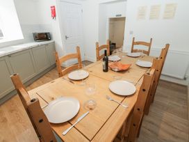 A dining room set with a wooden table and chairs at Salvin Cottage in Alston