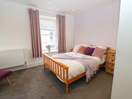 A bedroom with a bed, dresser, and window at Salvin Cottage in Alston